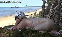 एक सुडौल सुनहरे बालों वाली माँ समुद्र तट पर नीचे और गंदी हो जाती है।